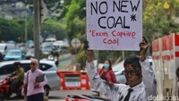 Aktivis membawa pesan dalam aksi yang menyerukan penghentian pembiayaan proyek batu bara captive atau pembangkit yang digunakan untuk memenuhi kebutuhan energi industri tertentu. 