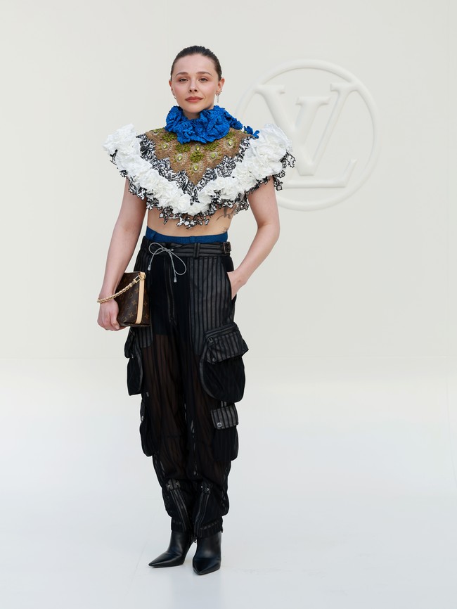 Chloë Grace Moretz justru mengambil pendekatan yang berlawanan dengan ekspektasi. Alih-alih memilih keseluruhan look yang feminin, ia memadukan cropped top penuh detail ruffle dengan cargo trousers yang utilitarian tanpa kehilangan karakter fashion-forward. (Foto: Getty Images for Louis Vuitton/Arnold Jerocki) Chloë Grace Moretz justru mengambil pendekatan yang berlawanan dengan ekspektasi. Alih-alih memilih keseluruhan look yang feminin, ia memadukan cropped top penuh detail ruffle dengan cargo trousers yang utilitarian tanpa kehilangan karakter fashion-forward. (Foto: Getty Images for Louis Vuitton/Arnold Jerocki)