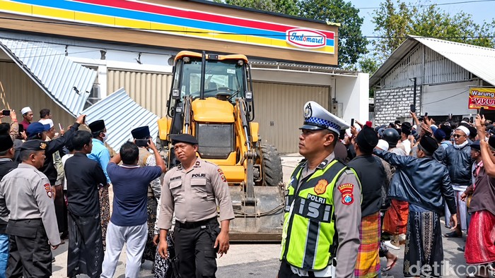 Saat massa melakukan aksi pengrusakan sebuah minimarket menggunakan ekskavator di Pamekasan