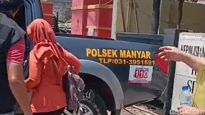 Wanita korban teror DC diantar menggunakan mobil polisi dari Polsek Manyar menuju Polres Gresik