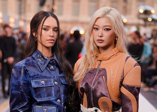 Personel termuda KATSEYE asal Korea Selatan, Yoonchae pun terlihat memukau dengan rambut pirangnya. Ia mengenakan color-blocked moto jacket, micro pants hitam, sepatu pumps berwarna burgundy, serta tas Louis Vuitton Noe serupa. Foto: Getty Images