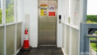 Pintu lift modern berbahan stainless steel yang dilengkapi dengan papan informasi operasional dan prioritas bagi penyandang disabilitas, lansia, serta ibu hamil tampak terpasang rapi di area Jembatan Penyeberangan Orang (JPO) kawasan Jalan Frontage Ahmad Yani.