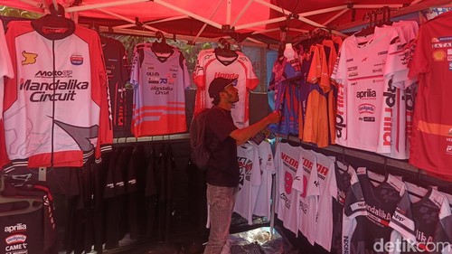 Seorang warga negara asing (WNA) memilih baju di lapak seorang penjual di depan Sirkuit Mandalika, Jumat (9/10/2026).