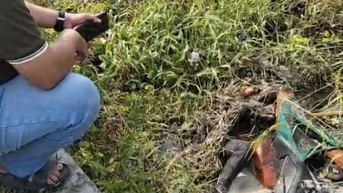 Jenazah pria bersama motor CBR-nya yang ditemukan di sebuah parit, nyaris tertutup semak dan rumput, di Sidoarjo.