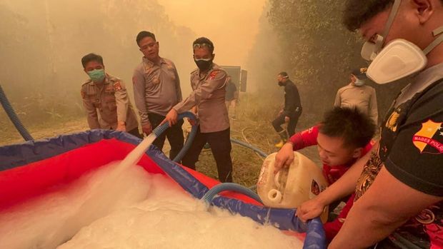 Polisi membantu pemadaman karhutla di tengah pekatnya asap yang membuat langit Barito Selatan menguning. (dok Polres Barsel) Polisi membantu pemadaman karhutla di tengah pekatnya asap yang membuat langit Barito Selatan menguning. (dok Polres Barsel)