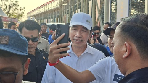 Presiden Ri ketujuh, Joko Widodo (Jokowi), berwafoto dengan penonton saat menyaksikan balapan MotoGP Mandalika, Sabtu (10/10/2026). (Ahmad Viqi/detikBali)