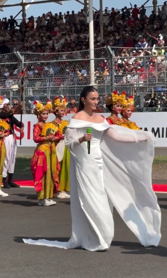 Penyanyi dan aktris berusia 40 tahun ini tampil cantik berbalut gaun putih berpotongan off shoulder. Siluet flowy dengan aksen cape menambah kesan anggun. Foto: Tangkapan layar Instagram/@themandalikagp