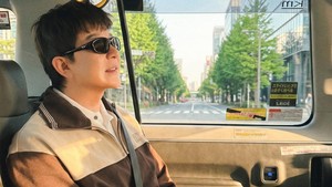 Tampil stylish dengan kacamata hitam di dalam taksi, Shindong pamer jawline makin tirus sambil menikmati suasana jalanan kota Tokyo. Foto: dok. Instagram @earlyboysd