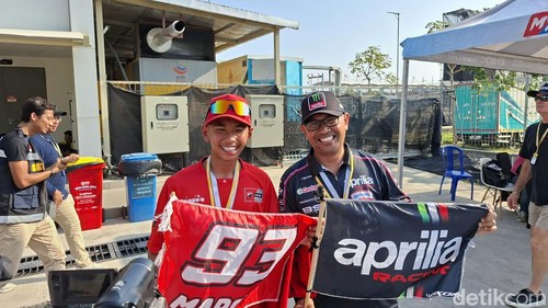 Pasangan ayah dan anak pendukung tim dan rider berbeda di MotoGP Mandalika, Minggu (11/10/2026).