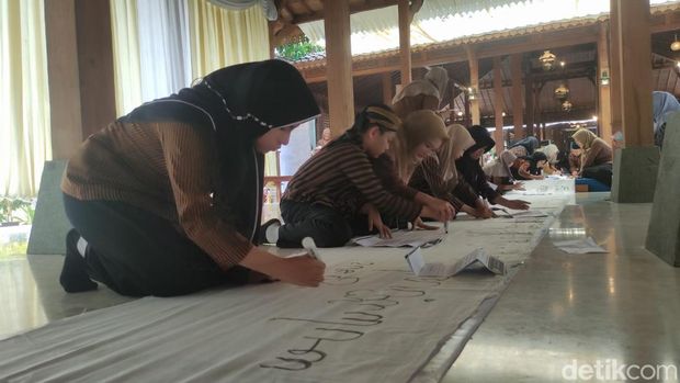 Prestasi sekolah Sidoarjo Siswa SD Antawirya Islamic Javanese School menuliskan aksara Jawa di atas kain sepanjang 600 meter di Pendopo Giri Kedaton, Junwangi, Krian, Sidoarjo, Minggu (11/10/2026).