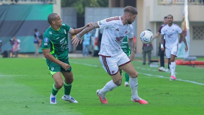 Striker PSM Makassar Lars Veldwijk dijaga ketat bek PSS Sleman Cleberson.
