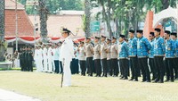 Kepala Pelaksana (Kalaksa) BPBD Jatim Gatot Soebroto berdiri tegap memimpin barisan peserta Upacara Peringatan Hari Jadi ke-81 Provinsi Jawa Timur di lapangan Gedung Negara Grahadi, Surabaya. Barisan yang terdiri dari unsur ASN, aparat kepolisian, hingga TNI tampak berdiri rapi dan tertib.