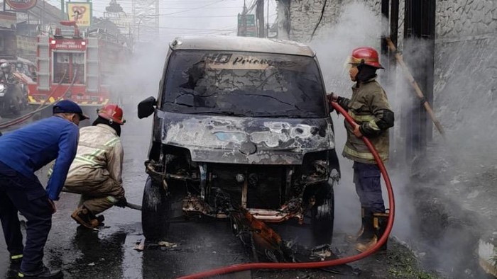 Petugas saat memadamkan api yang membakar mobil di Sukabumi