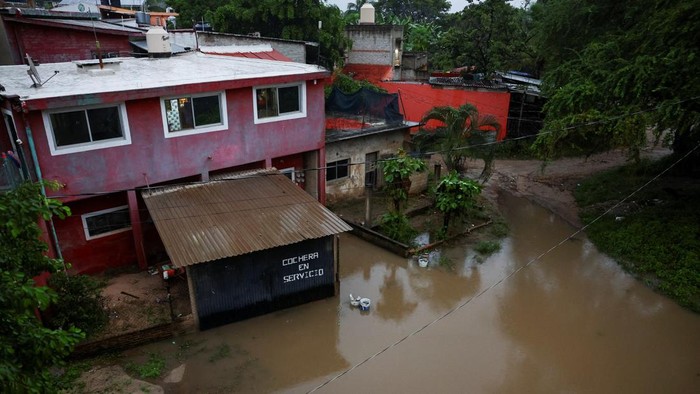 A man removes water from a building as Hurricane Simon approaches Mexico's Pacific coast, bringing heavy rain and strong winds to Manzanillo, Mexico, October 11, 2026. REUTERS/Daniel Becerril