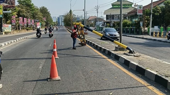 Petugas melepas portal yang roboh di ringroad timur, Maguwoharjo, Depok, Sleman, Selasa (13/10).