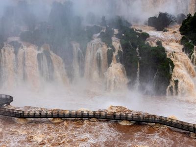 People stand as sections of the walkway and some trails remain closed due to the high water flow at Iguazu Falls River in Foz do Iguacu, Parana state, Brazil, October 13, 2026. REUTERS/Kiko Sierich