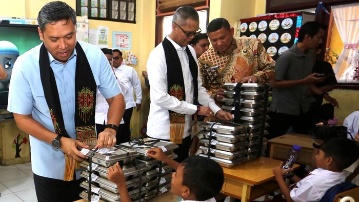 Kepala Badan Gizi Nasional (BGN) Sudaryono (kiri) bersama Anggota Komisi IV DPR TA Khalid (ketiga kanan) membagikan ompreng berisi Makanan Bergizi Gratis (MBG) kepada pelajar SD Negeri Cot Meuraja di Desa Cot Karieng, Aceh Besar, Aceh, Selasa (13/10/2026). Kunjungan kerja Kepala BGN ke Provinsi Aceh itu untuk memastikan dan melihat pelaksanaan MBG agar berjalan dengan baik mulai wilayah perkotaan hingga daerah tertinggal, terdepan dan terluar serta memantau penerapan standar operasional prosedur di tempat penyedia makanan. ANTARA FOTO/Irwansyah Putra