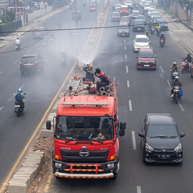 Kurangi Dampak Karhutla, Petugas Lakukan Penyemprotan Air di Palembang