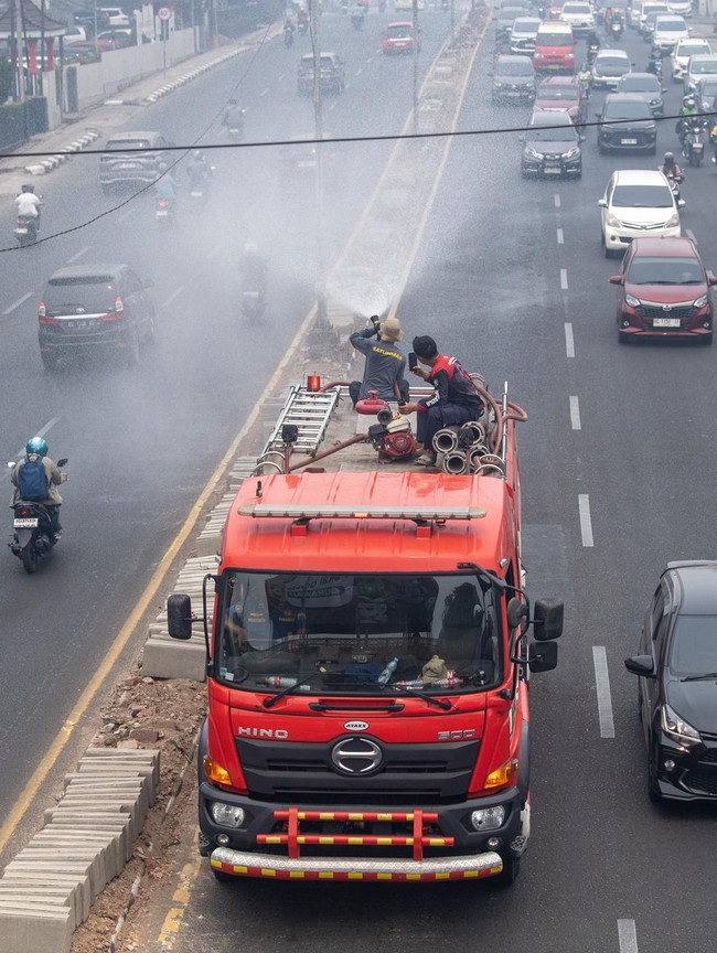 Kurangi Dampak Karhutla, Petugas Lakukan Penyemprotan Air di Palembang