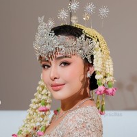 Bagian leher kebaya memiliki potongan persegi yang memperlihatkan area tulang selangka. Model ini memberikan kesan anggun sekaligus modern pada busana pengantin tradisional. Kebaya tersebut juga memiliki lengan panjang berbahan transparan dengan hiasan bordir dan payet senada. Foto: Instagram/@prscillas