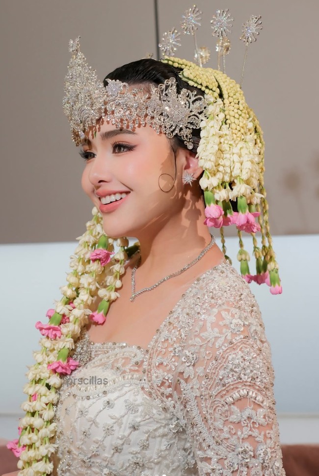 Riasan wajah Amanda terlihat flawless dengan hasil akhir yang memberikan kesan segar. Bagian mata dipertegas menggunakan eyeliner dan bulu mata lentik, sementara perona pipi bernuansa merah muda membuat wajahnya tampak merona. Lipstik pink dengan hasil akhir lembut melengkapi riasan sehingga penampilannya terlihat manis dan feminin. Foto: Instagram/@prscillas