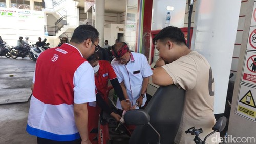 Gubernur Wayan Koster membantu operator SPBU mengisi BBM ke motor pelanggan, Kamis (15/10/2026).