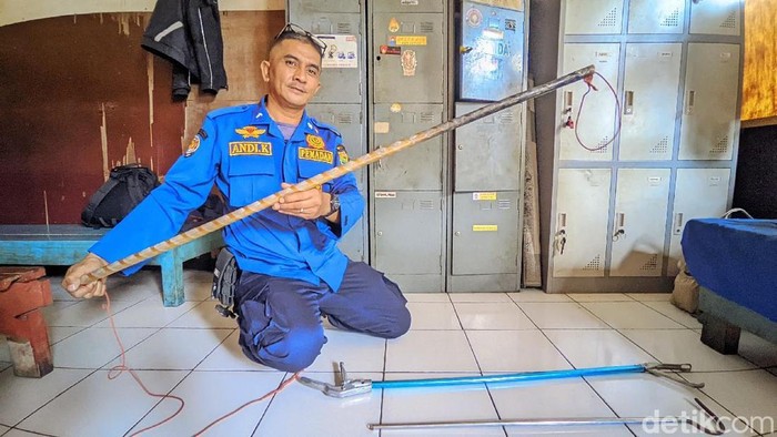 Petugas Damkar Ciamis menunjukan peralatan untuk evakuasi ular.