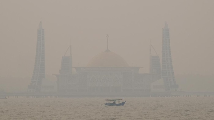 Imbauan waspada kabut asap kiriman di Sultra Sebuah perahu nelayan melintasi kawasan Masjid terapung Al Alam yang mulai tertutup asap di Kendari, Sulawesi Tenggara, Selasa (13/10/2026). BMKG setempat mengimbau pengguna moda transportasi darat, laut, dan udara di Sulawesi Tenggara agar meningkatkan kewaspadaan terhadap potensi penurunan jarak pandang akibat kabut asap kiriman dari Maluku dan Papua Selatan yang meningkat pada sore hingga malam hari. ANTARA FOTO/Andry Denisah/nz