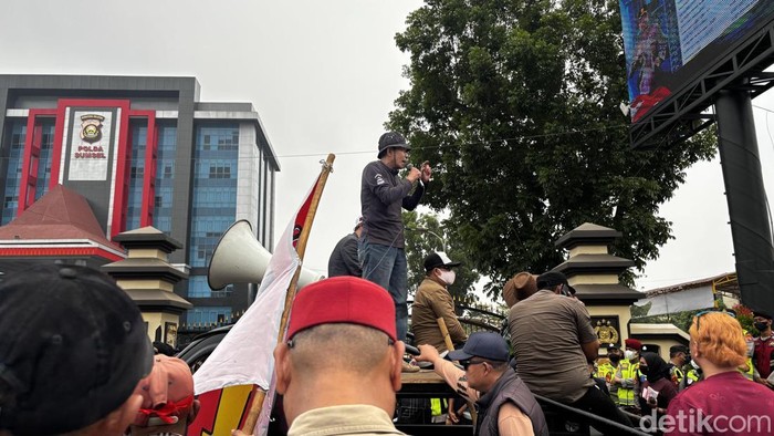 Massa dari FASS melakukan orasi di depan Mapolda Sumsel