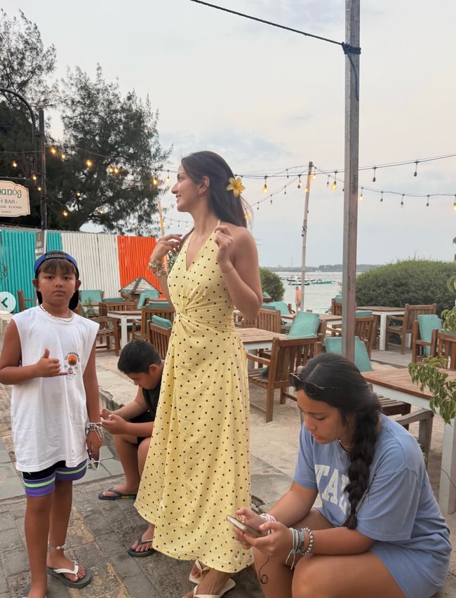 Di salah satu kesempatan Nia tampak menggenakan dress panjang polkadot berwarna kuning. Dress halter neck itu dipadukannya dengan sandal jepit putih.&nbsp;Foto: Instagram/@ramadhaniabakrie