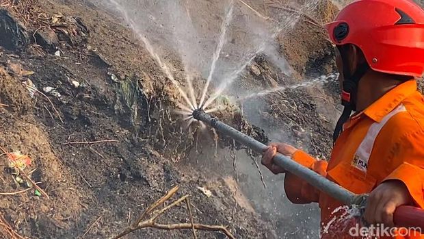 Petugas berupaya memadamkan kebakaran TPA Parepare menggunakan suntik air.