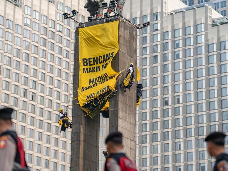 Greenpeace Bentangkan Spanduk di Patung Bundaran HI