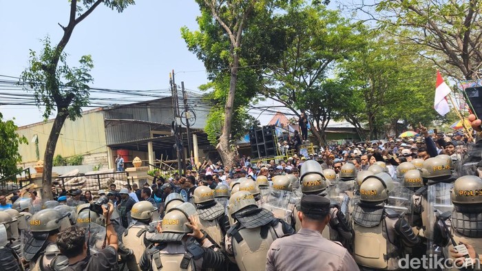 Massa saat terlibat aksi dorong dengan aparat kepolisian di Jalan Suratmo, Kecamatan Semarang Barat, Kota Semarang, dalam sidang vonis Bupati Pati nonaktif, Sudewo, Rabu (21/10).