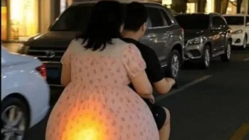 Ketika penumpang motor punya lampu sein sendiri. Pantulan cahaya oranye di bagian belakang gaun perempuan ini menciptakan ilusi seperti lampu kendaraan. Bikin salah fokus! Foto: Boredpanda