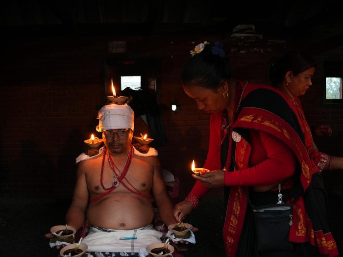 BHAKTAPUR, NEPAL-OCTOBER 21: Nepalese devotees sit with oil lamps placed on their bodies during Dashain festival celebrations at Baramahini Temple in Bhaktapur, Nepal, on October 21, 2026. The ritual is observed as an expression of religious faith and devotion during Dashain, Nepalâs biggest Hindu festival, when devotees worship Goddess Durga and seek blessings for prosperity, good health and protection from evil. The ceremony reflects the rich religious and cultural traditions preserved by local communities in the Kathmandu Valley. (Photo by Sunil Pradhan/Anadolu via Getty Images)