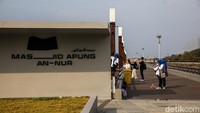 Pengunjung terlihat memanfaatkan area di sekitar masjid untuk berjalan-jalan, bersantai, hingga mengabadikan momen dengan berfoto.