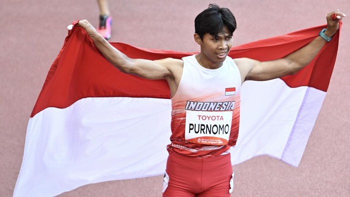 Pelari para Indonesia Saptoyogo Purnomo membentangkan bendera Merah Putih usai finis pada final 100 meter T37 putra Asian Para Games 2026 di Stadion Paloma Mizuho, Nagoya, Aichi, Jepang, Rabu (21/10/2026). Saptoyogo berhasil meraih medali perak usai finis pada urutan kedua dengan catatan waktu 11,35 detik. ANTARA FOTO/M Risyal Hidayat/agr