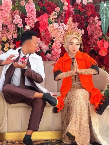Viral di Instagram, pasangan pengantin penggemar Naruto tampil unik mengenakan jubah Hokage dan memamerkan pose jurus ninja di pelaminan saat resepsi.