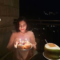 Pada malam harinya, Prilly kembali merayakan ulang tahun sederhana dengan tiup lilin di balkon penginapannya. Kenakan busana off shoulder berwarna pink, Prilly tampil fresh dengan lipstik natural yang mewarnai bibirnya. Foto: Instagram/@prillylatuconsina96