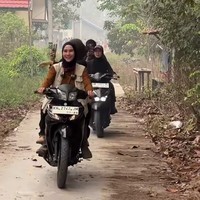 Dengan menaiki motor, Zaskia mengitari desa sambil melihat beberapa lahan yang juga ikut terbakar. Penampilannya tampak simpel dan sederhana dengan memadukan celana panjang hitam dan kaos lengan panjang coklat. Ia juga melengkapi penampilannya dengan rompi coklat muda serta hijab hitam.&nbsp;Foto: Instagram/@zaskiadyamecca