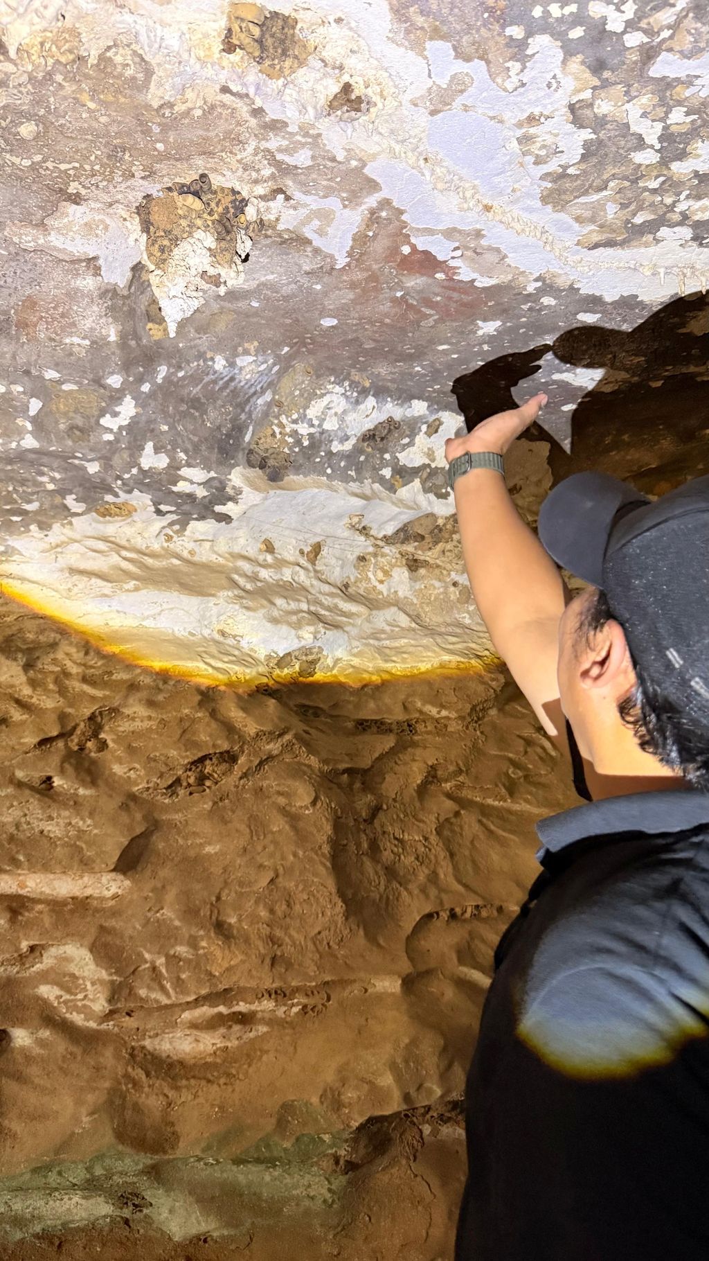 ASIA-WEATHER/INDONESIA-CAVE Seorang peneliti menunjuk ke arah lukisan batu di dalam sebuah gua di Maros-Pangkep, provinsi Sulawesi Selatan, Indonesia, 12 Oktober 2026. Badan Riset dan Inovasi Nasional/Dokumentasi melalui REUTERS