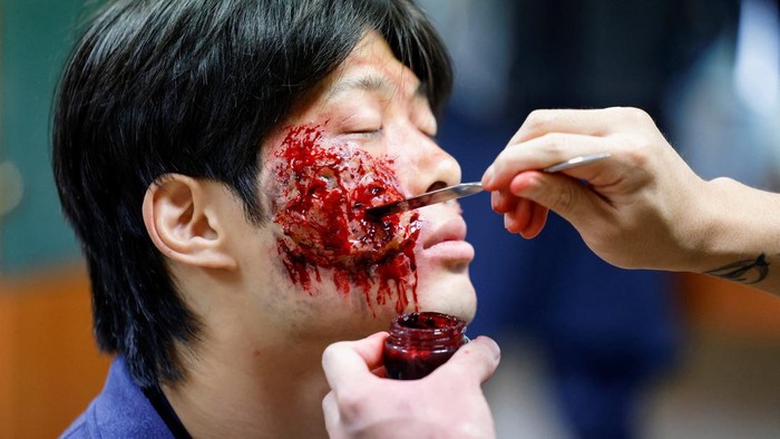 Participants watch actors dressed as zombies perform beside a bus during the Seoul City Tour Bus Zombie Attack event ahead of Halloween in Seoul, South Korea, October 21, 2026. REUTERS/Kim Soo-hyeon