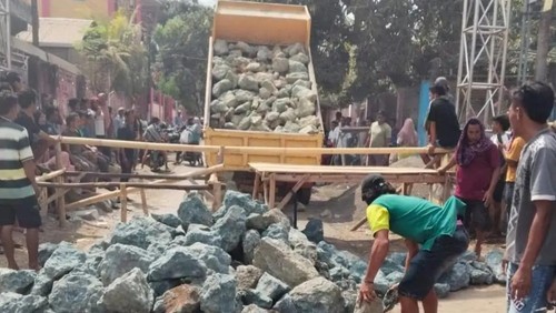 Truk menurunkan muatan batu besar untuk memblokade jalan di perbatasan Desa Diha dan Ncera, Kecamatan Belo, Kabupaten Bima, NTB, Jumat (23/10/2026). (Foto: Dok. Istimewa)