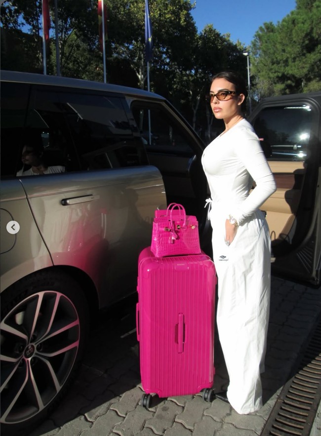 Masih dengan seri tas Hermes Birkin Crocodile, kali ini wanita 32 tahun itu tampak berpose memamerkan tas seri tersebut dalam warna fuchsia yang matching dengan kopernya.vFoto: Dok. Instagram Georgina Rodriguez