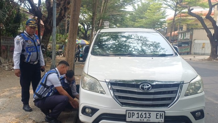 Dishub Makassar gembok mobil parkir di bahu jalan.