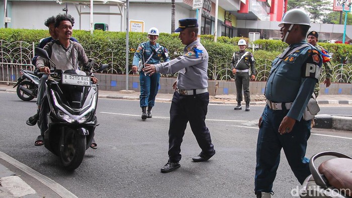 Petugas gabungan menertibkan pengendara sepeda motor yang melanggar aturan lalu lintas saat Operasi Patuh Jaya 2026 di Jalan Kemanggisan Raya, Slipi, Jakarta, Senin (26/10/2026).