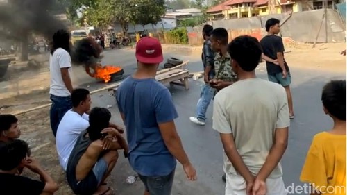 Warga menutup jalan dan membakar ban bekas di depan kantor Camat Woha, Kabupaten Bima, NTB, pada Senin (26/10/2026)
