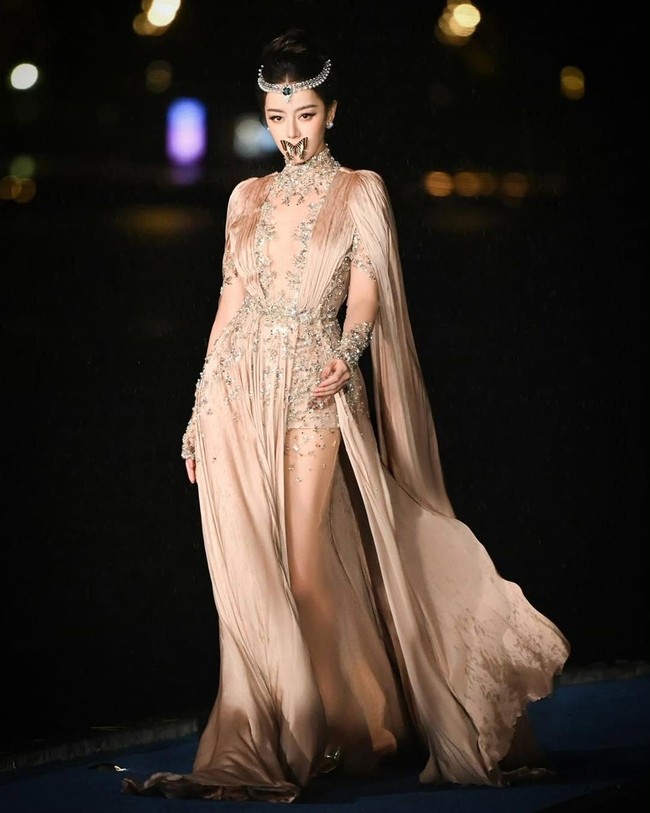 Aktris 34 tahun ini melengkapi gayanya dengan unik. Dia terlihat catwalk dengan bibirnya dihiasi kupu-kupu. Dilraba Dilmurat kemudian seolah-olah meniup lembut kupu-kupu itu hingga terbang ke udara. Foto: Dok. Instagram Zuhair Murad, Weibo Dilraba Dilmurat Fansite