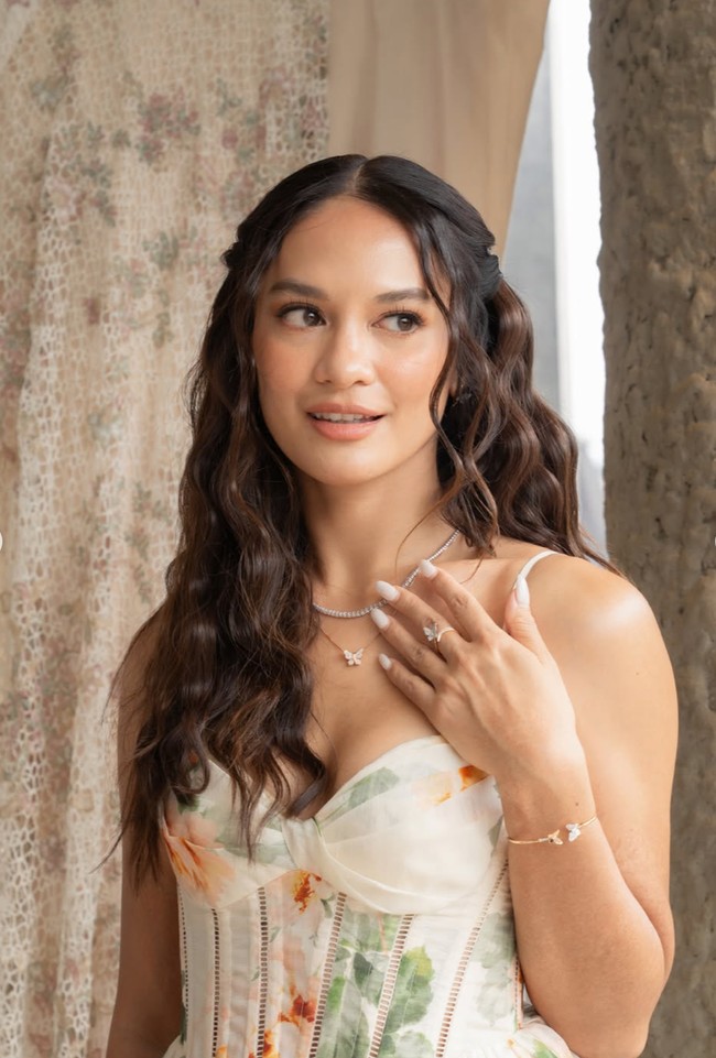Rambutnya tampak simpel terurai dengan model mermaid curl. Riasannya juga terlihat natural dan minimalis dengan warna coral yang soft.&nbsp;Foto: Instagram/@hanamalasan