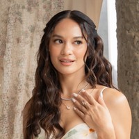 Rambutnya tampak simpel terurai dengan model mermaid curl. Riasannya juga terlihat natural dan minimalis dengan warna coral yang soft.&nbsp;Foto: Instagram/@hanamalasan